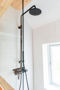 a shower in a bathroom with white tiles at Min Hus Anno 1875 in Bönstrup +17 photos