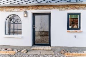 a house with a black door and two windows at Min Hus Anno 1875 in Bönstrup