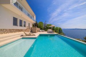 a house with a swimming pool next to the water at Villa Empress in Dramalj