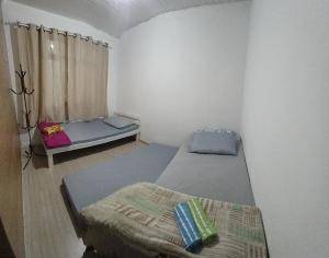 a room with two beds and a window at Casa J&G in Fazenda Rio Grande