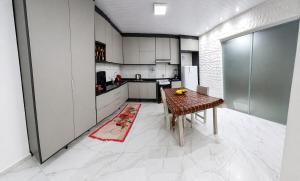 a kitchen with a wooden table and a refrigerator at Casa J&G in Fazenda Rio Grande