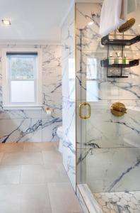 a bathroom with a shower with marble walls at Breakwater Inn in Kennebunkport