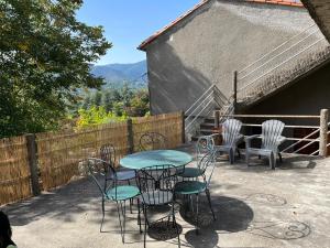 a table and chairs sitting on a patio at Le Mas Comprés !! in Avèze