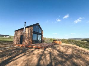a small wooden house on top of a field at Ostoja Janowice in Janowice