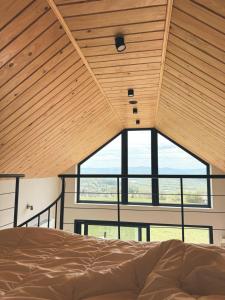 a bedroom with a bed and a large window at Ostoja Janowice in Janowice