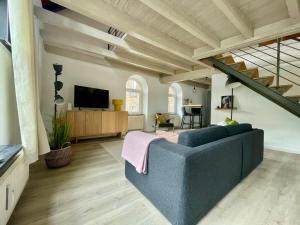 a living room with a blue couch and a tv at Urlaubsschmiede Mosel in Traben-Trarbach
