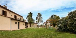 a yard with a building and a grass field at Agriturismo Poggio Agli Ulivi in Riotorto