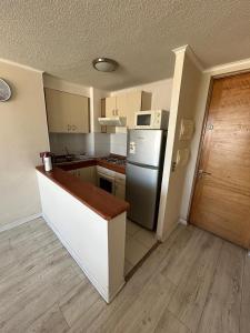 a small kitchen with a refrigerator and a counter at Departamento Centro Concepción in Concepción +7 photos