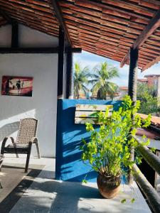a patio with a blue wall and a chair and a plant at Blue Day in Canoa Quebrada
