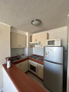 a kitchen with a stainless steel refrigerator and cabinets at Departamento Centro Concepción in Concepción