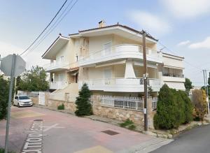 a building on a street with a car parked in front at evaxila papaflessa 机场附近 in Glyka Nera