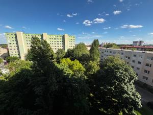 a view of trees in front of tall buildings at Samaria Central Apartment in Šamorín