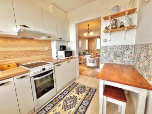 a kitchen with white cabinets and a stove top oven at Samaria Central Apartment in Šamorín