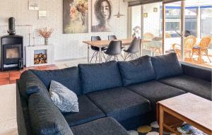 a blue couch in a living room with a fireplace at Awesome Home In Thyborøn With Wifi in Thyborøn