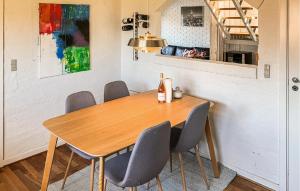 a dining room table with four chairs and a bottle of wine at Awesome Home In Thyborøn With Wifi in Thyborøn
