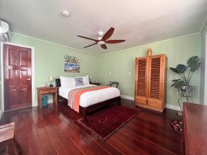 a bedroom with a bed and a ceiling fan at The Jungle Hotel and Bar in Bocas Town