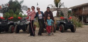 a family posing in front of four four wheelers at Hacienda Hotel Colpa in Chincha +2 photos