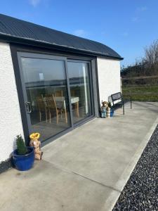 a patio with sliding glass doors with a table and chairs at The Old Cowhouse in Falleens