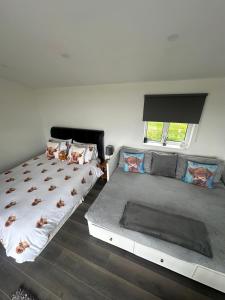 a bedroom with two beds and a window at The Old Cowhouse in Falleens