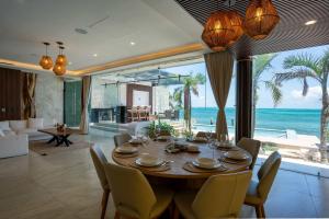 a dining room with a table and a view of the ocean at Villa Magdalena - 7BR - Oceanfront with Heated Pool in Cancún
