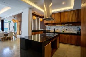 a kitchen with a black counter and a dining room at Villa Magdalena - 7BR - Oceanfront with Heated Pool in Cancún