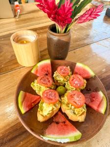 a plate of breakfast sandwiches on a table with a vase with flowers at Seúl Haus in El Sunzal +9 photos