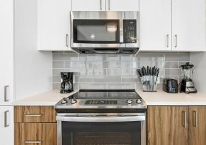 a kitchen with a stove and a microwave at High-end Modern 3BR 3BA Condo Assembly Square in Somerville