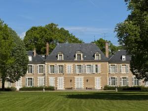 a large house with a roof on a lawn at Château de Puchesse in Sandillon