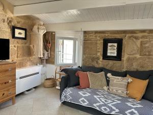 a living room with a blue couch and a stone wall at The three bell towers apartment in Alghero