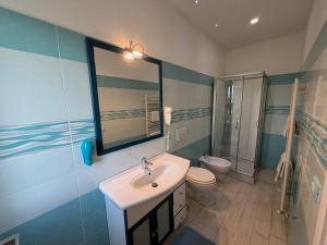a bathroom with a sink and a toilet and a mirror at VILLA NATURA in Corropoli