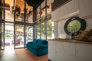 a kitchen with a blue couch in a room with windows at Selene Houseboat Polańczyk in Polańczyk