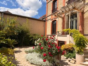 a garden with flowers in front of a building at Villa des dames 40m2,jardin fleuri in Sainte-Savine