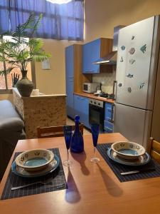 a kitchen with a wooden table with plates and wine glasses at Galliu'S home in Selargius +10 photos