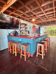 a blue bar with wooden stools in a restaurant at The Jungle Hotel and Bar in Bocas Town