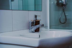 a bathroom sink with a faucet and a mirror at HoTELBLU in Santiago