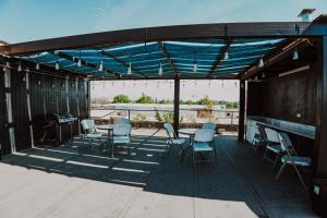 a covered patio with chairs and tables and a grill at HoTELBLU in Santiago