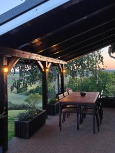 a wooden table and chairs on a patio at Počitniška hiša Kuferland in Dobrovnik +9 photos