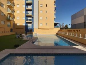 a swimming pool in front of a building at Carnaval 16 in Isla Cristina
