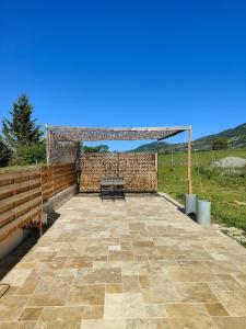a patio with a bench and a wooden fence at Gite Aubanel' Drôme Provencale in Saint-Auban-sur-Ouvèze