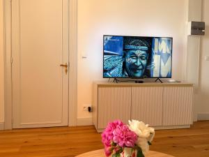 a room with a vase of flowers and a painting at Villa des dames 40m2,jardin fleuri in Sainte-Savine