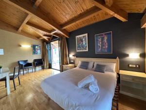 a bedroom with a large bed and a table and chairs at RoomRural Hotel Iru-Bide Lumbier in Lumbier