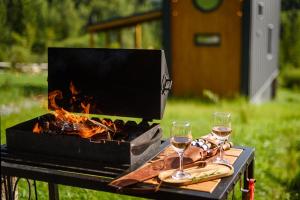 a grill with two glasses of wine on a table at Silence cabin in Myta