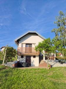 a house with a balcony on top of a yard at Počitniška hiša Kuferland in Dobrovnik