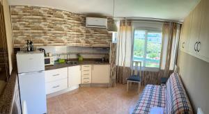 a kitchen with white cabinets and a brick wall at Promar Playa 255 in La Pineda