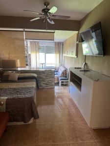 a room with two beds and a kitchen with a ceiling fan at Promar Playa 255 in La Pineda