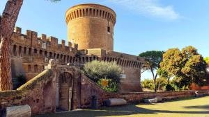 a building with a clock tower in a park at CasadellemeravigliediGiulia in Ostia Antica