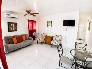 a living room with a couch and a tv at Kenridge Residences in Saint James