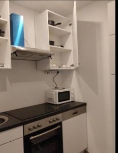 a kitchen with white cabinets and a microwave on a counter at Mozart Salzburg Residence in Salzburg