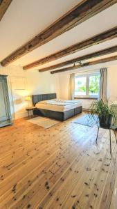 a bedroom with a bed and a wooden floor at Ferienwohnung Lütt Quickborn in Quickborn