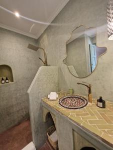 a bathroom with a sink and a mirror at Riad Dar Yamna Marrakech in Marrakesh